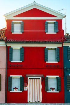 Lovely house facade and colorful walls in Burano, Venice. Burano island canal, colorful houses and boats, Venice landmark, Italy. Europe