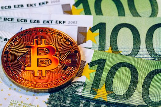Golden bitcoin over Euro money. Bitcoin cryptocurrency. Crypto currency concept. Bitcoin with euro bills. Bitcoins stacked on euro banknotes.