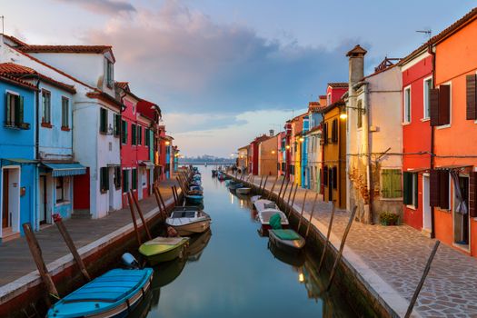 Street view with colorful buildings in Burano island at night, Venice, Italy. Architecture and landmarks of Burano, Venice postcard. Scenic canal and colorful architecture in Burano island near Venice, Italy