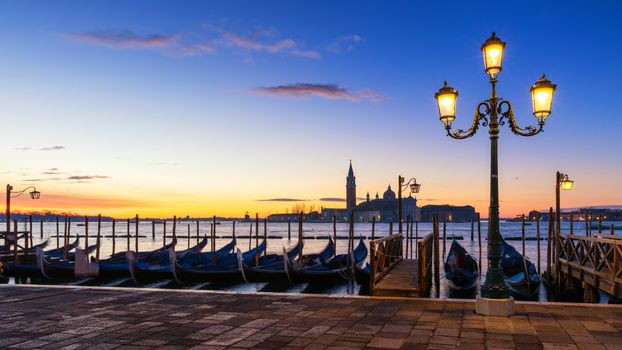 Scenic view of San Giorgio Maggiore, gondolas and lamp at colorful sunrise, Venice, Italy. Sunset in Venice. Gondolas at Saint Mark's Square and church of San Giorgio Maggiore on background, Italy, Europe