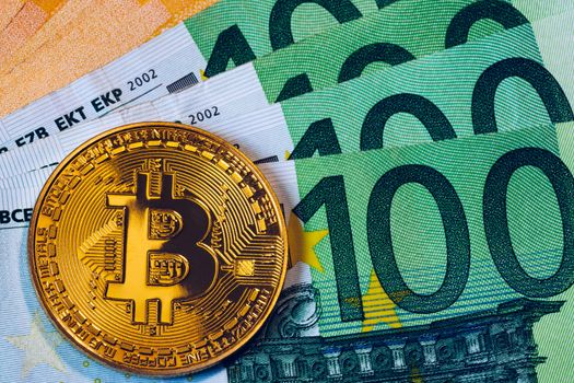 Golden bitcoin over Euro money. Bitcoin cryptocurrency. Crypto currency concept. Bitcoin with euro bills. Bitcoins stacked on euro banknotes.
