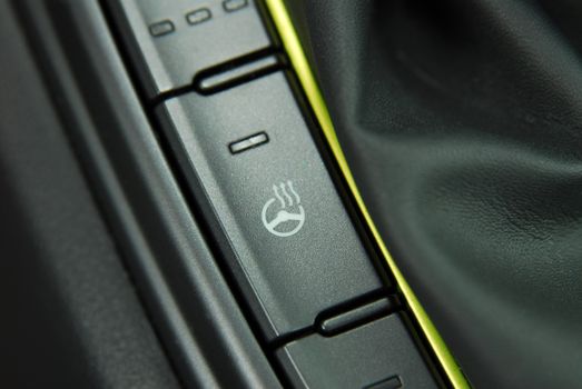 the control panel of a modern car with a button for heating the steering wheel