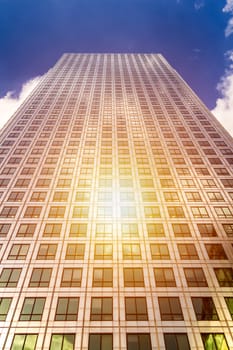 Cityscape featuring modern office exterior from a low angle at sunset.