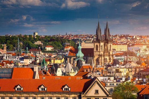 Prague red roofs and dozen spires of historical Old Town of Prague. Cityscape of Prague on a sunny day. Red rooftops, spires and the Charles Bridge and Vltava River in the background. Prague, Czechia.