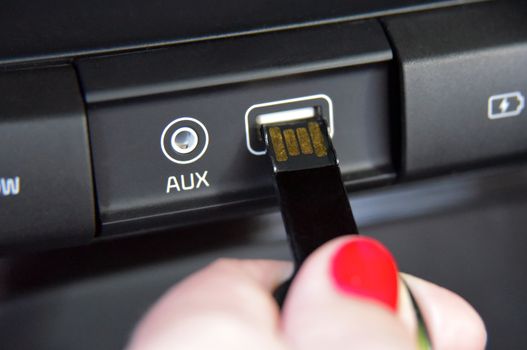 Hand plugging a key shaped USB drive into port