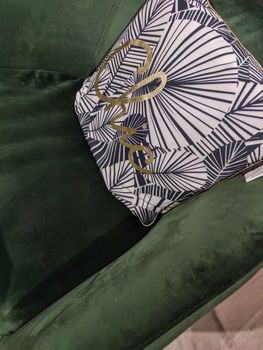 a mulicolor pillow on a green sofa