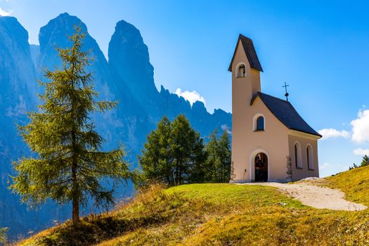 Chapel of San Maurizio at Passo Gardena, South Tyrol, Italy.  View to path to small white chapel San Maurizio and Dolomiti mountain. San Maurizio chapel on the Gardena Pass, South Tyrol, Italy.