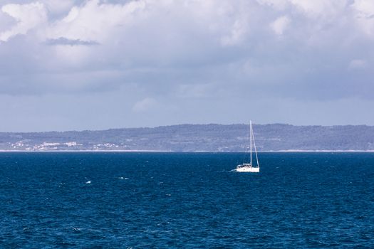 Sailboat in the sea in the evening sunlight with mountains background, luxury summer adventure, active vacation in Mediterranean sea, Croatia. Sailing ship luxury yacht with white sails in the Sea. 