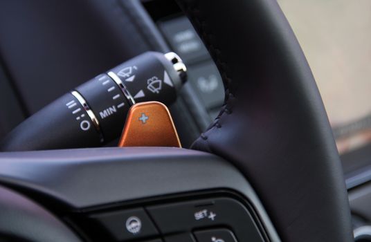 manual gear changing stick on a car's steering wheel, car interior detail