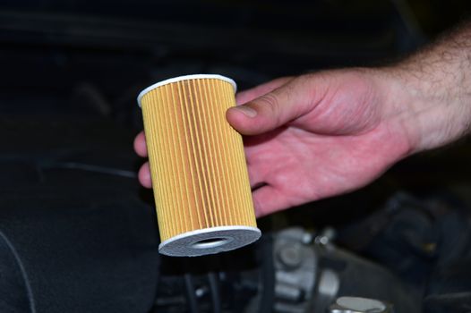 Repairman holding an new car oil filter