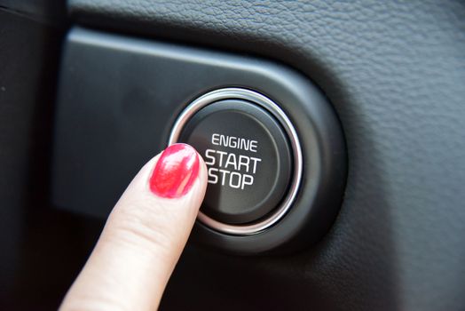 Women activates button to start and stop for car engine