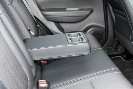 armrest in the luxury passenger car with cup holder between the front seats