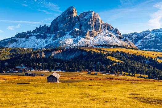 Stunning view of Peitlerkofel mountain from Passo delle Erbe in Dolomites, Italy. View of Sass de Putia (Peitlerkofel) at Passo delle Erbe, with wooden farm houses, Dolomites, South Tyrol, Italy.
