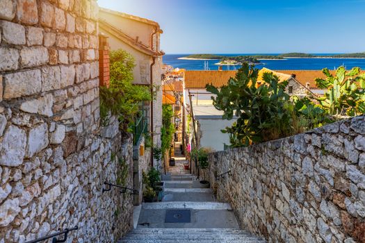 Beautiful street with flowers in the Hvar town, Hvar island, Dalmatia, Croatia. Old Mediterranean street, Hvar town. Old Adriatic town Hvar. Medieval street. Popular touristic destination of Croatia.