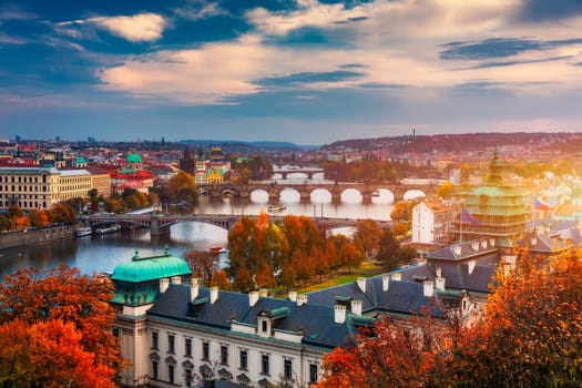 Autumn view to Charles bridge on Vltava river in Prague, Czech Republic. Autumn view to Charles Bridge, Prague old town and Vltava river. Czechia. Scenic autumn view of the Old Town with red foliage.