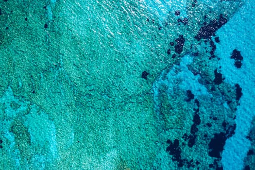 Sea surface aerial view. Background image of the turquoise sea. Deep sea and corals. Aerial drone shot of turquoise water, space for text. Aquamarine background. Sea Aerial view.