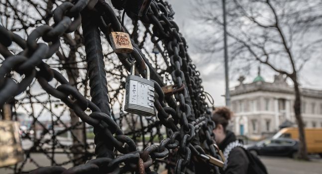 Dublin, Ireland - February 12, 2019: Padlocks of love hanging from a work of art near Custom House on a winter day