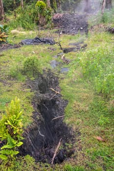Leilani Estate, Hawaii, USA. - January 14, 2020: Devastation in parts untouched by 2018 lava. Black Crevasses appear in ground of all terrain letting poisonous gases and vapors out. Green bottom.