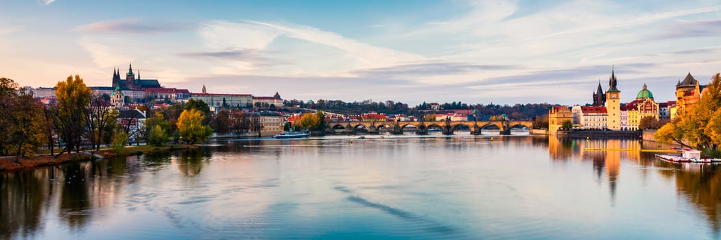 Autumn view to Charles bridge on Vltava river in Prague, Czech Republic. Autumn view to Charles Bridge, Prague old town and Vltava river. Czechia. Scenic autumn view of the Old Town with red foliage.