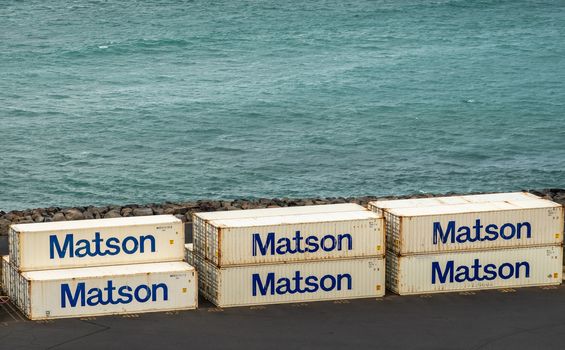 Kahului, Maui,, Hawaii, USA. - January 13, 2020: Ocean port. Closeup of white Matson shipping containers stacked on quay with azure ocean as backdrop.