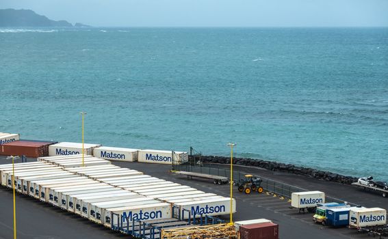 Kahului, Maui,, Hawaii, USA. - January 13, 2020: Matson shipping container yard filled with white boxes on trailers on quay bordering azure ocean.