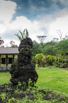 Leilani Estate, Hawaii, USA. - January 14, 2020: Centuries old black Lava Tree under blue sky with white clouds in green State Monument Park.