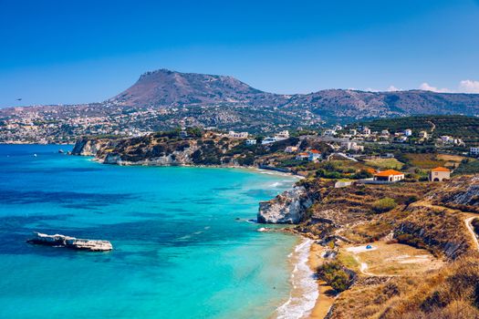 Greek holidays, beautiful Kalyves village with turquoise sea in Crete island, Greece. View of Kalyves beach, Crete. Tourists relaxing on the beach and views to the mountains, Kalyves, Crete, Greece