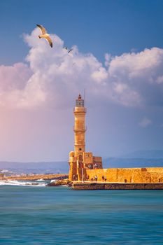Venetian harbour and lighthouse in old harbour of Chania with seagulls flying over, Crete, Greece. Old venetian lighthouse in Chania, Greece. Lighthouse of the old Venetian port in Chania, Greece.