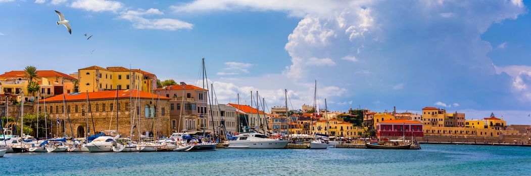Old port of Chania with flying seagulls. Landmarks of Crete island. Bay of Chania at sunny summer day, Crete Greece. View of the old port of Chania, Crete, Greece. The port of chania, or Hania. 