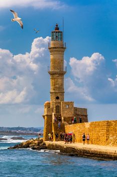 Venetian harbour and lighthouse in old harbour of Chania with seagulls flying over, Crete, Greece. Old venetian lighthouse in Chania, Greece. Lighthouse of the old Venetian port in Chania, Greece.