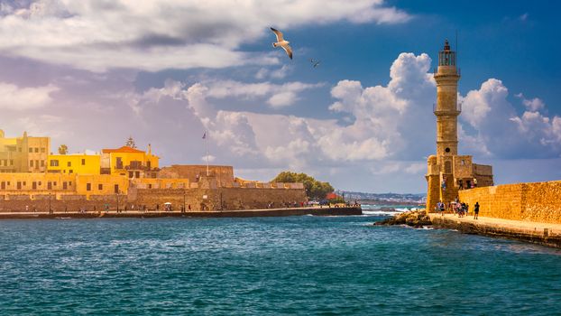 Venetian harbour and lighthouse in old harbour of Chania with seagulls flying over, Crete, Greece. Old venetian lighthouse in Chania, Greece. Lighthouse of the old Venetian port in Chania, Greece.