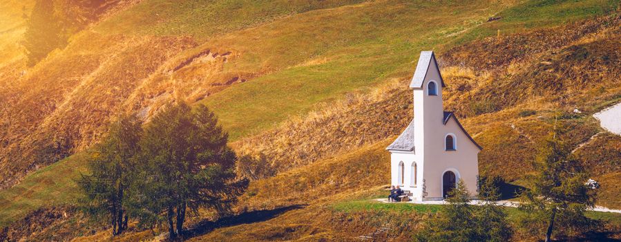 Chapel of San Maurizio at Passo Gardena, South Tyrol, Italy.  View to path to small white chapel San Maurizio and Dolomiti mountain. San Maurizio chapel on the Gardena Pass, South Tyrol, Italy.