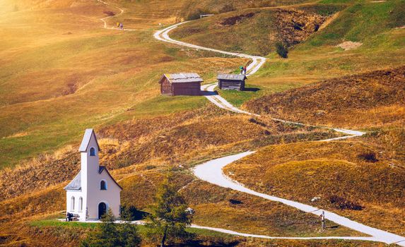Chapel of San Maurizio at Passo Gardena, South Tyrol, Italy.  View to path to small white chapel San Maurizio and Dolomiti mountain. San Maurizio chapel on the Gardena Pass, South Tyrol, Italy.