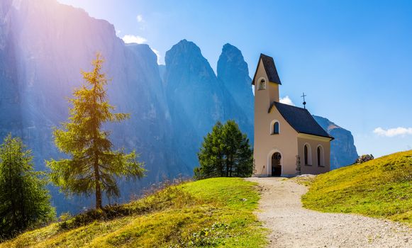 Chapel of San Maurizio at Passo Gardena, South Tyrol, Italy.  View to path to small white chapel San Maurizio and Dolomiti mountain. San Maurizio chapel on the Gardena Pass, South Tyrol, Italy.