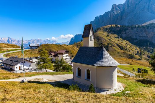 Chapel of San Maurizio at Passo Gardena, South Tyrol, Italy.  View to path to small white chapel San Maurizio and Dolomiti mountain. San Maurizio chapel on the Gardena Pass, South Tyrol, Italy.