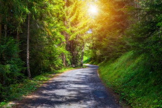 Mountain road. Landscape with rocks, sunny sky with clouds and beautiful asphalt road in the evening in summer. Vintage toning. Travel background. Highway in mountains.  