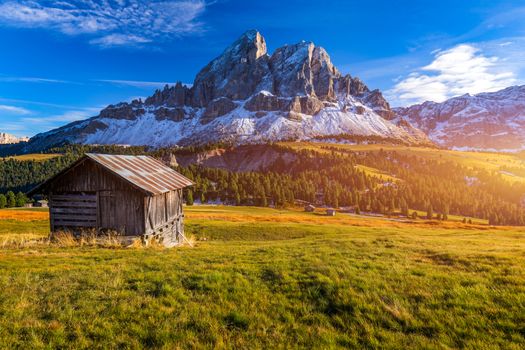 Stunning view of Peitlerkofel mountain from Passo delle Erbe in Dolomites, Italy. View of Sass de Putia (Peitlerkofel) at Passo delle Erbe, with wooden farm houses, Dolomites, South Tyrol, Italy.