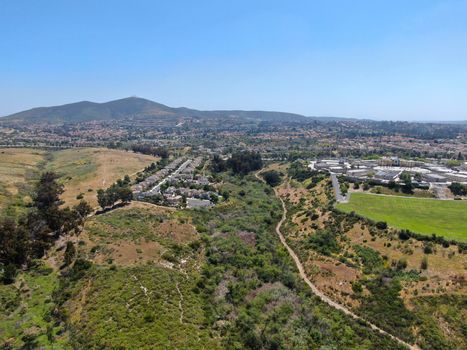 Aerial view of upper middle class neighborhood with residential houses in green valley, South California, USA.