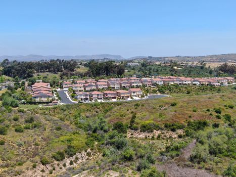 Aerial view of upper middle class neighborhood with residential houses in green valley, South California, USA.