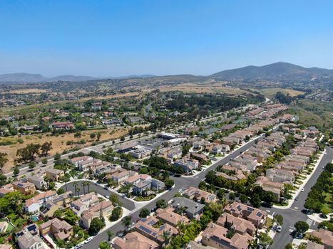 Aerial view of upper middle class neighborhood with residential houses in green valley, South California, USA.