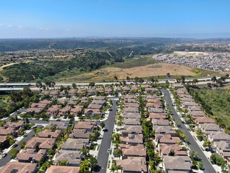 Aerial view of upper middle class neighborhood with residential houses in green valley, South California, USA.