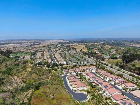 Aerial view of upper middle class neighborhood with residential houses in green valley, South California, USA.