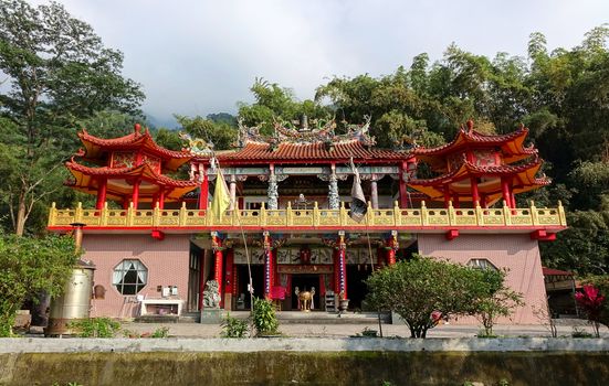 PINGTUNG, TAIWAN -- FEBRUARY 5, 2016: The Baolian Temple with its decorated column and a large bronze incense burner is nestled in the foothills of the Pingtung Mountains.