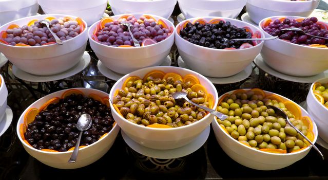 Variety assortment diverse of fresh healthy tasty olives in white bowls