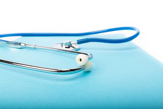 medical record and blue stethoscope close-up on white background in studio