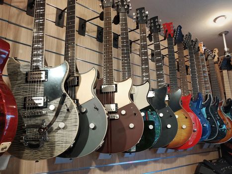 Hanging guitars in a row on the wall in the music shop