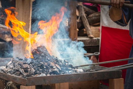 Braga, Portugal - May 23, 2018: Blacksmith who makes metal chafer on a street market giving the passers-by the Roman era that the city knew during the event Braga Romana