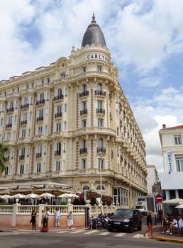 Cannes, France - June 28, 2018: View of the famous corner dome of the Carlton International Hotel located on the Croisette boulevard. Unidentified people are walking along street.