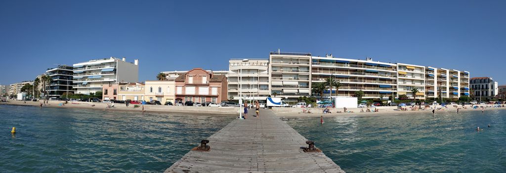 Cannes, France - July 8, 2018: Public beach at the end of the Promenade de la Croisette. Unidentified people relax on the beach.