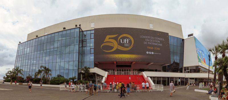 Cannes, France - June 28, 2018: Wide view of the Film Festival Palace in Cannes. Cannes hosts the annual Cannes Film festival from 1949. Unidentified people are walking along the promenade.